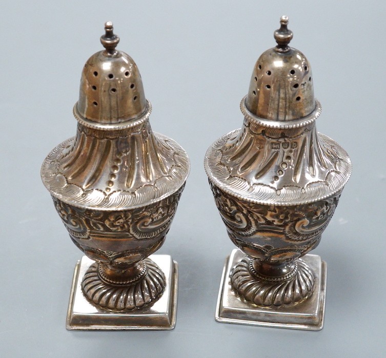 A pair of late Victorian silver vase shaped pedestal pepperettes, by Josiah Williams & Co, London, 1897, 10.5cm, 120 grams.